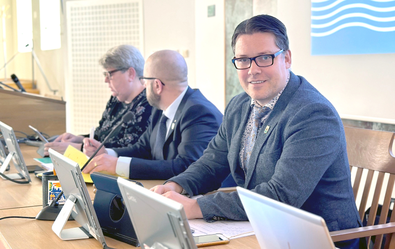Tre politiker framför sina datorskärmar i Rådhussalen i Karlshamn.